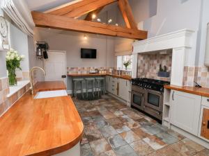 a large kitchen with a wooden counter top at The Stables and West Wing in York