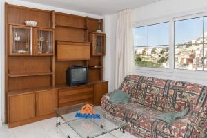 - un salon avec un canapé et une télévision dans l'établissement Villas Cap Blanc Ii, Pta 11, à Cullera