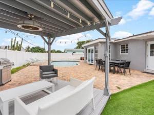 a patio with a table and chairs and a grill at Modern 3BR2 HEATED POOL GRILL Big BACKYARD in Hollywood