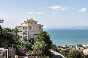 - un bâtiment sur une colline à côté de l'océan dans l'établissement Villas Cap Blanc Ii, Pta 11, à Cullera