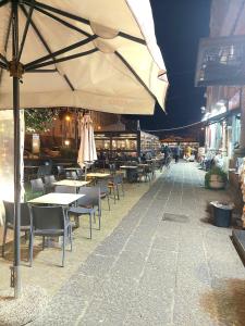 ein Restaurant mit Tischen, Stühlen und einem Sonnenschirm in der Unterkunft Concept b&b naples in Neapel