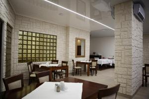 a dining room with tables and chairs and a brick wall at Izabella in Puławy
