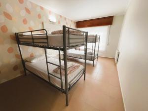 a room with three bunk beds in a room at Albergue O Cruceiro in Caldas de Reis
