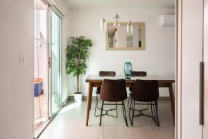 comedor con mesa de madera y sillas en #CasaMare - Privada a una cuadra del mar con AC, en Ensenada