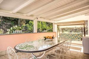 une salle à manger avec une table et des chaises en verre dans l'établissement Green nest your paradise your private garden, à Massa Lubrense