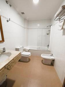 a bathroom with a sink and a toilet and a tub at Albergue O Cruceiro in Caldas de Reis