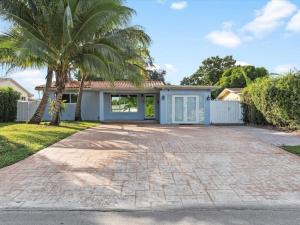 a house with a palm tree and a driveway at Modern 4BR2 HEATED POOL GRILL Big backyard in Miami Gardens