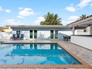 uma piscina em frente a uma casa em Modern 4BR2 HEATED POOL GRILL Big backyard em Miami Gardens