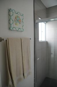 a bathroom with a shower and towels on a wall at #CasaMare - Privada a una cuadra del mar con AC in Ensenada