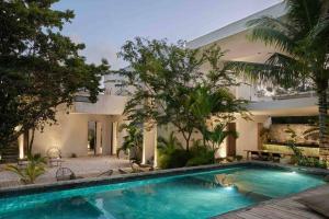 a swimming pool in front of a house at Villa 16Tulum in Tulum