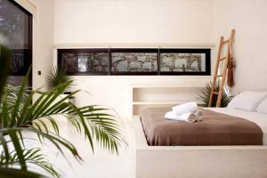 a bedroom with a bed and a plant at Villa 16Tulum in Tulum +75 photos
