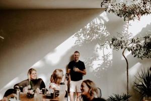 a man standing in front of a table with people at Villa 16Tulum in Tulum