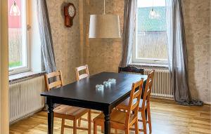 a dining room table with chairs and a clock on the wall at 4 Bedroom Lovely Home In Södra Sandby in Södra Sandby