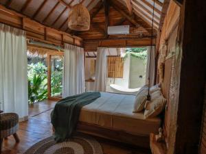 um quarto com uma cama num quarto com uma janela em La Siesta bungalows & Cuisine em Gili Air