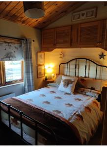 um quarto com uma cama grande e um tecto em madeira em Cosy wood cabin in rural area near national park em Cumnock