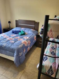 1 dormitorio con 1 cama con edredón azul en Calido departamento en Ushuaia 7 en Ushuaia