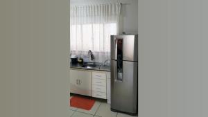 a kitchen with a stainless steel refrigerator and a sink at Casa Executiva Orla Morena in Campo Grande