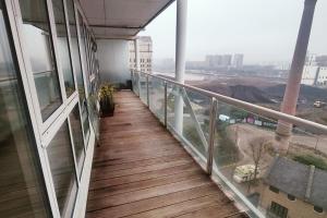 a balcony of a building with a wooden walkway at Custom House Apartments in London