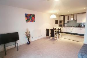 a living room with a kitchen and a table and chairs at Custom House Apartments in London