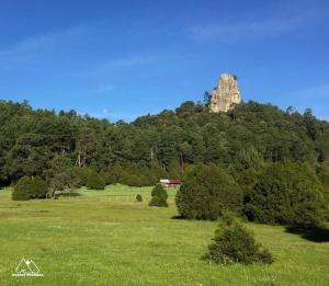 a large field with a rock in the background at Mágica Cabaña en Parque La Pirámide in La Florida