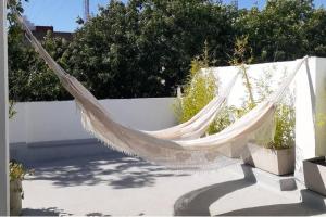 a hammock hanging on a white fence at Depto para descansar y disfrutar in Buenos Aires