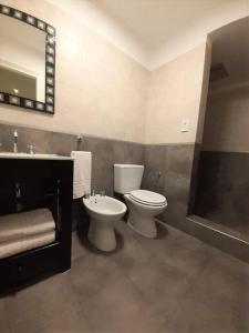 a bathroom with a toilet and a sink and a mirror at Depto para descansar y disfrutar in Buenos Aires