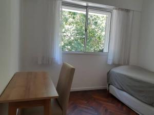 1 dormitorio con mesa, cama y ventana en Depto para descansar y disfrutar en Buenos Aires