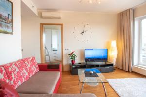 a living room with a couch and a tv at Wilde Guest Apartment Tigutorn in Tartu