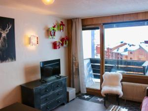 a living room with a television and a chair and a window at Studio Tignes, 1 pièce, 4 personnes - FR-1-449-52 in Tignes