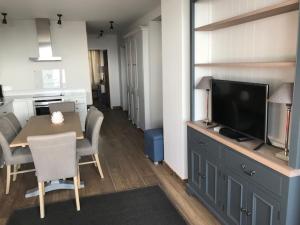 a kitchen and dining room with a table and a television at 3 pièces au pied des pistes avec balcon et WIFI à Tignes - FR-1-449-50 in Tignes