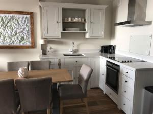 a kitchen with white cabinets and a table and chairs at 3 pièces au pied des pistes avec balcon et WIFI à Tignes - FR-1-449-50 in Tignes