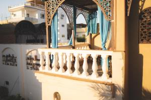 a balcony of a house with a white railing at Villa Nile House Luxor in Luxor