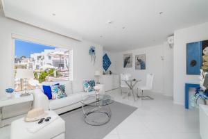 een witte woonkamer met een witte bank en een tafel bij Lani's Suites de Luxe - Adults Only in Puerto del Carmen
