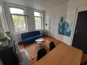 uma sala de estar com uma mesa e um sofá azul em Amiens magnifique appartement Frida em Amiens