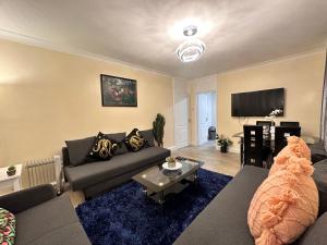 - un salon avec un canapé et une table dans l'établissement Posh 2-Bedroom, Living Room, Kitchen & 1.5 Bathroom, à Londres