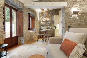 a living room with a couch and a stone wall at El Pajar de Jafre , Costa Brava Empordà 