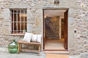 a stone building with a bench with pillows on it at El Pajar de Jafre , Costa Brava Empordà 