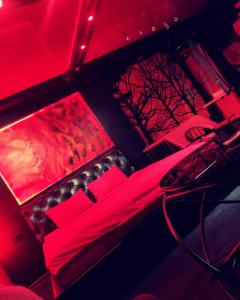 a room with red lights and a bed with chairs at "DREAM ROOM" Тематические апартаменты Харьков! Цоколь! in Kharkiv