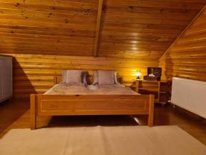 Lucky Rönk vendégház في Vîlcele: غرفة نوم بسرير في غرفة خشبية