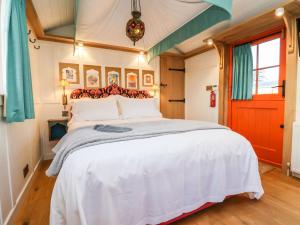 a bedroom with a large white bed with a red door at The Storyteller in York