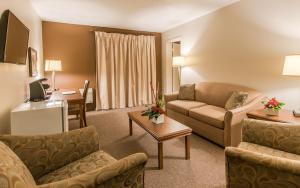 a hotel room with a couch and a table at Hotel de la Rive in Sorel