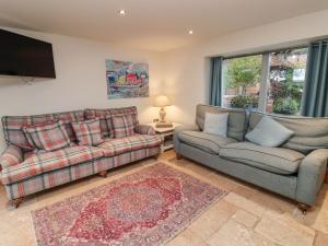uma sala de estar com dois sofás e uma televisão em Hornington Lodge em York