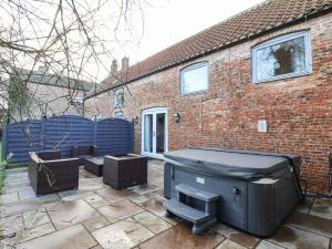 a patio with a large black piano in front of a brick house at Hornington Lodge in York