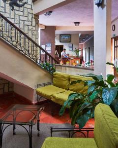 科潘魯伊納斯的住宿－科潘廣場酒店，带沙发和楼梯的客厅