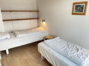 Duas camas num quarto com paredes brancas e pisos em madeira em Skjernaa-ferie/ Andersen Invest em Skjern