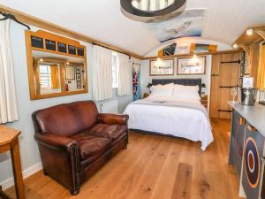 a bedroom with a bed and a leather couch at The Fenton in York
