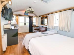 a bedroom with a white bed and a kitchen at The Fenton in York