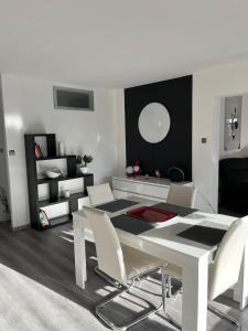 a white dining room with a white table and chairs at l'Ecrin du Bonheur in Turckheim