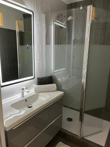 a white bathroom with a sink and a shower at l'Ecrin du Bonheur in Turckheim