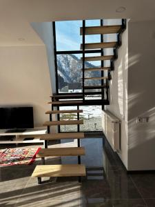 a staircase in a room with a large window at LUMA Sadgeri (Borjomi) in Borjomi